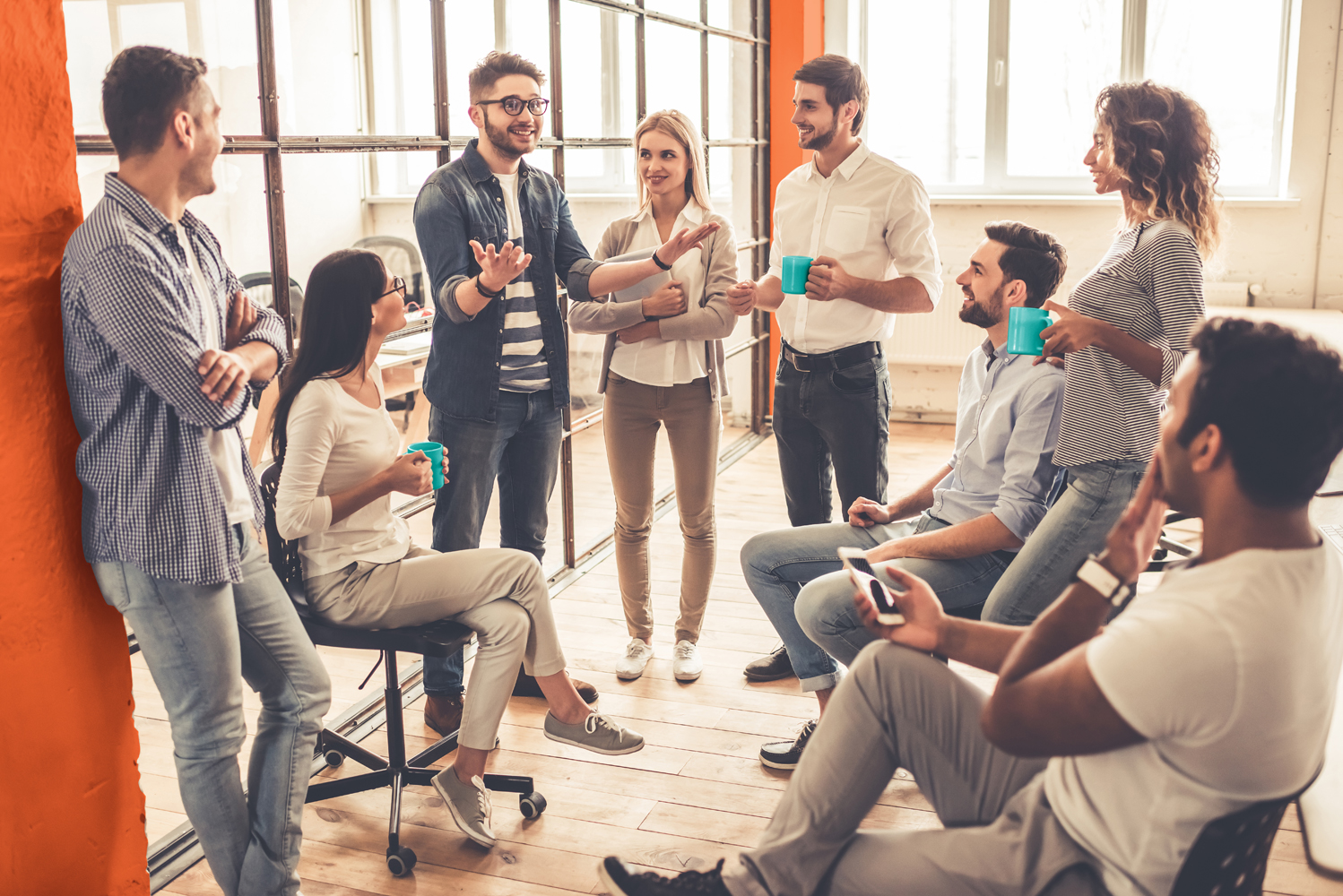 Successful young business people are talking and smiling during the coffee break in office