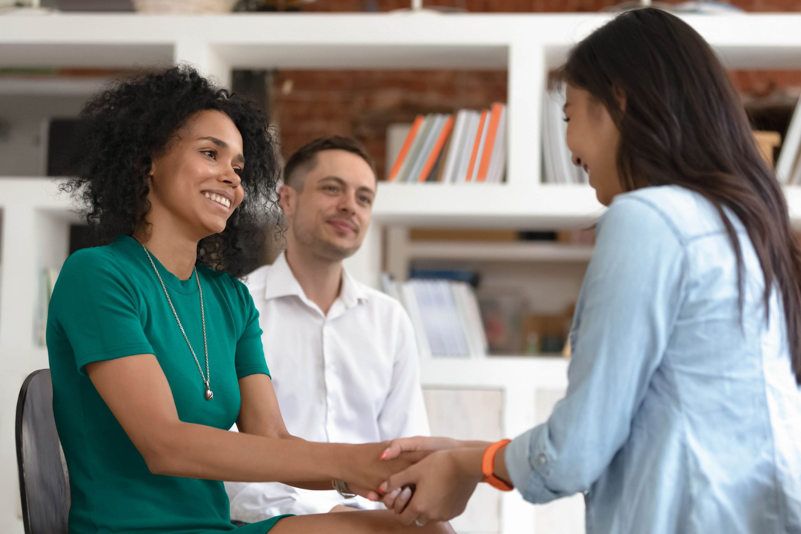 A couple of female work colleagues shaking hands.