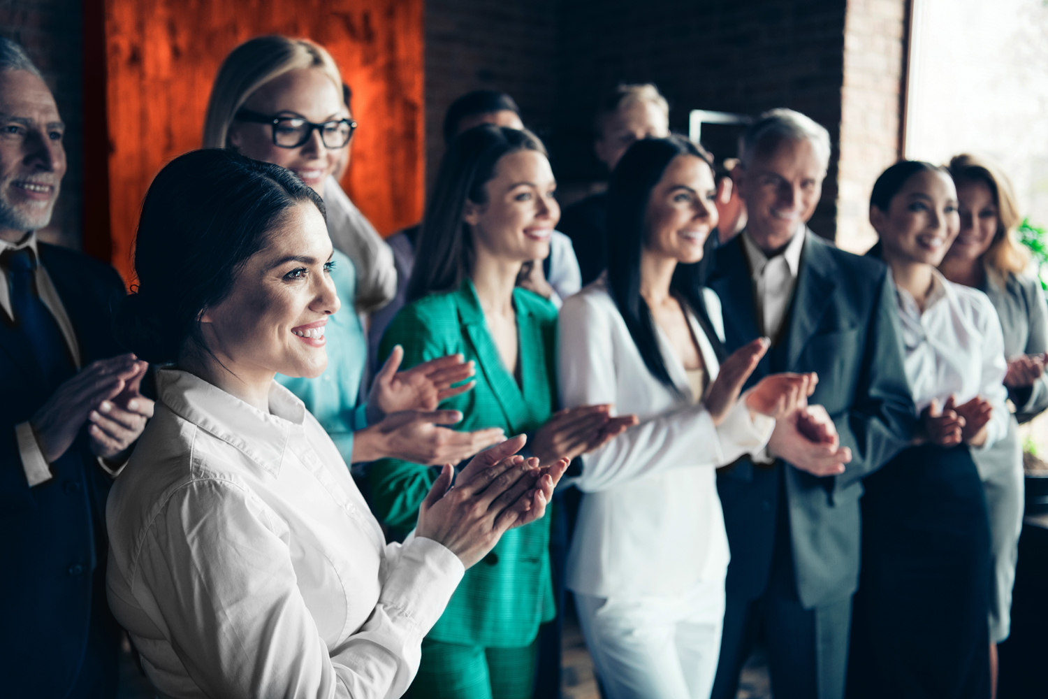 Close up side profile blurry view photo different age members business people stand she her he him his together best brigade show appreciation clap hands arms project power formal wear jackets shirts