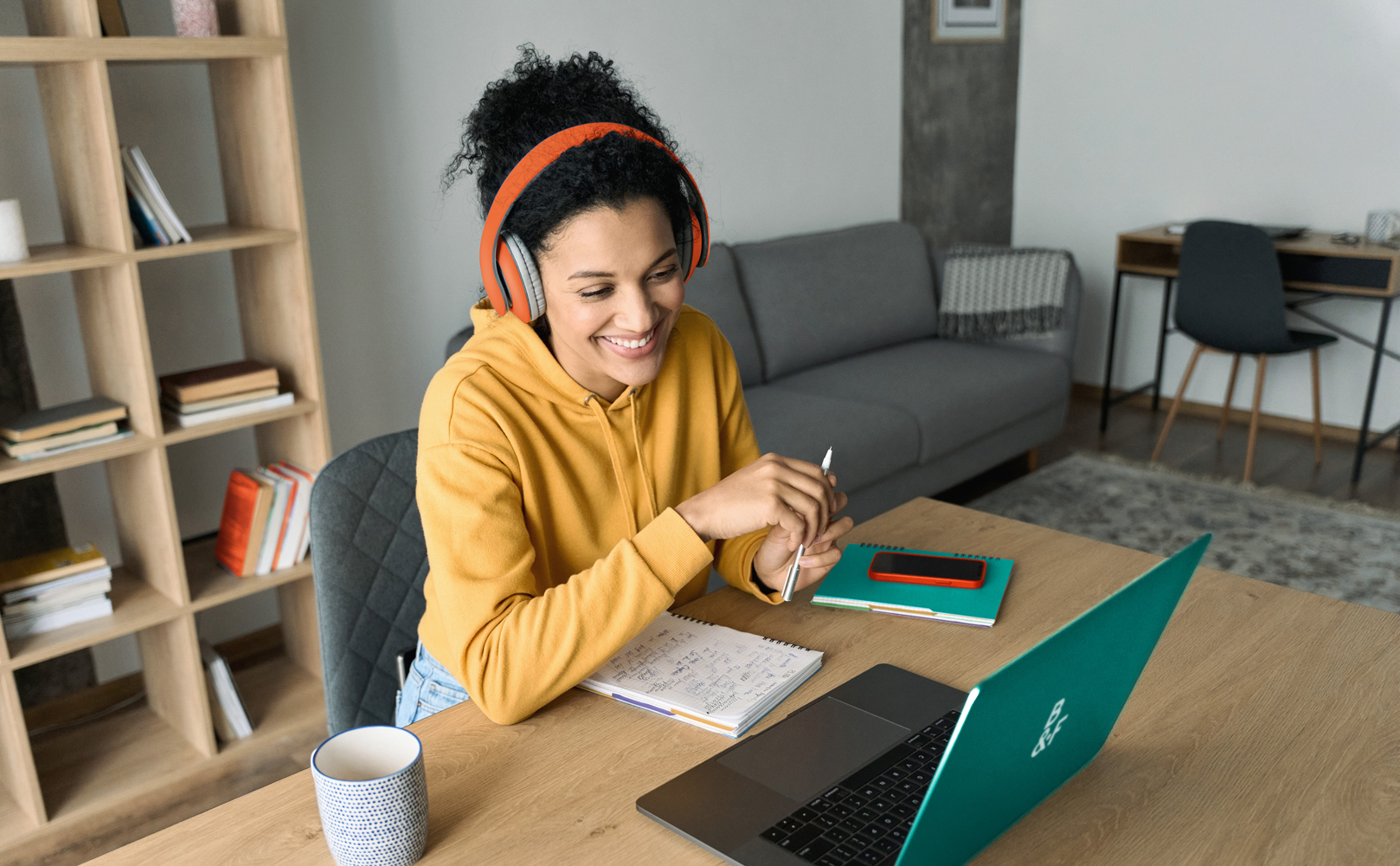 Young happy smiling adult student wearing headphones having a virtual education class.