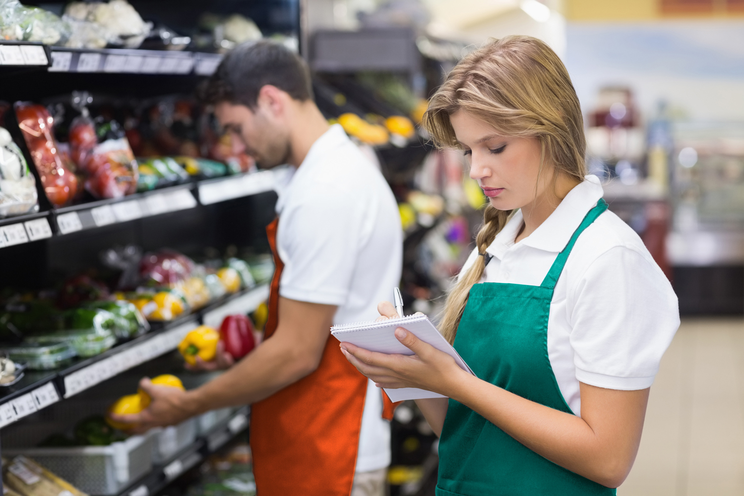 Staff, woman writing on notepad at supermarket