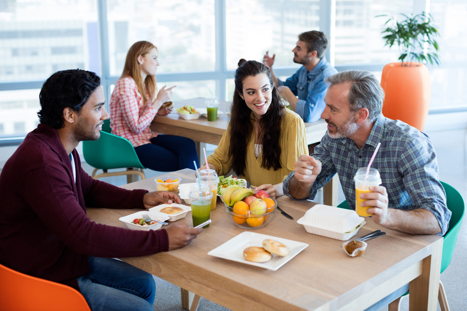 Creative business team eating lunch together in canteen